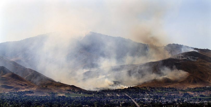 A brush fire burns into Number 1 Canyon west of Wenatchee, Wash., Sunday, Sept. 9, 2012, in a view looking west from East Wenatchee. Overnight lightning strikes sparked dozens of new fires in Washington state. (Associated Press)
