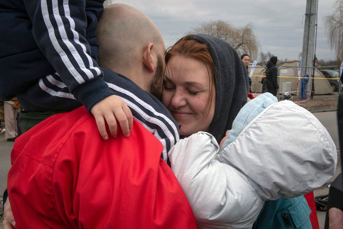 Ukrainian man Yevgen Chornomordenko 34, reunites with his family at the border crossing in Medyka, Poland on Sunday, March 6, 2022. Chonomordenko had been waiting for 11 days on the Polish side of the border for this wife, Alina, and two children to arrive from the Ukrainian capital, which had woken up to Russian shelling on Feb. 24. War had broken out at home just days after his arrival in the Polish city of Wroclow, near Germany, for a job installing solar panels. “I never believed war would start,’’ Chornomordenko said.  (Visar Kryeziu)