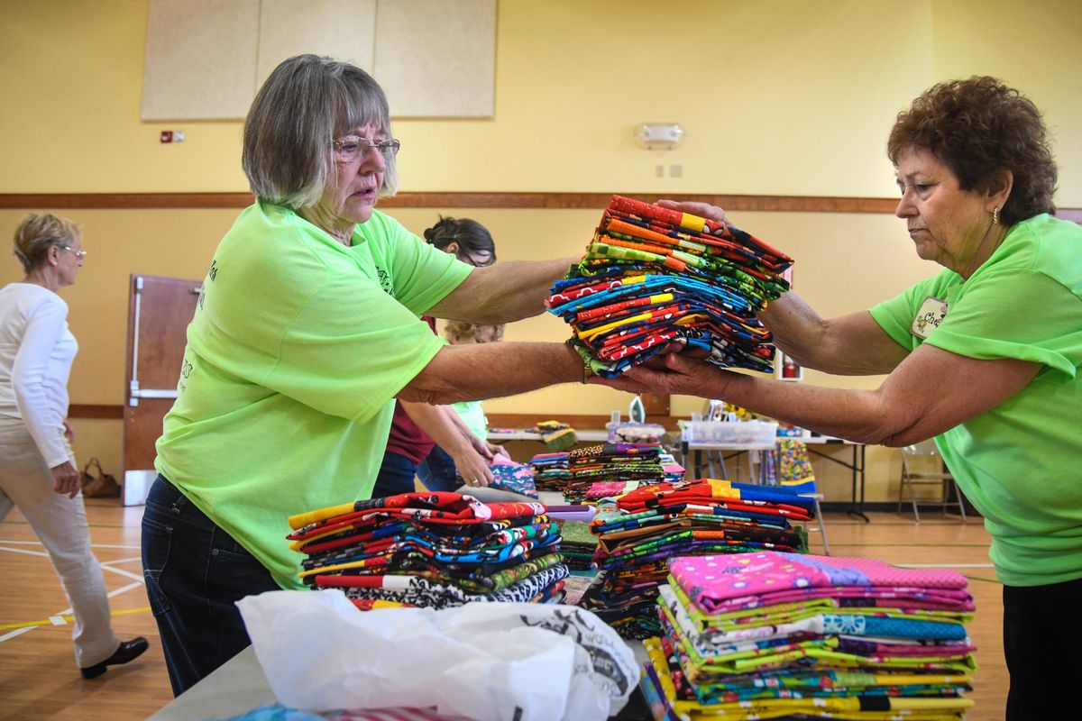 Joyce Beach, hands a stack of 25 pillow covers to Cherry Edwards during the Ryan’s Case for Smiles event, Thursday, Sept. 13, 2018, at Trinity Baptist Church. The group has produced over 10,000 pillowcases over the years for children at Providence Sacred Heart Children’s Hospital, Shriners Hospital and the Ronald McDonald House. (Dan Pelle / The Spokesman-Review)