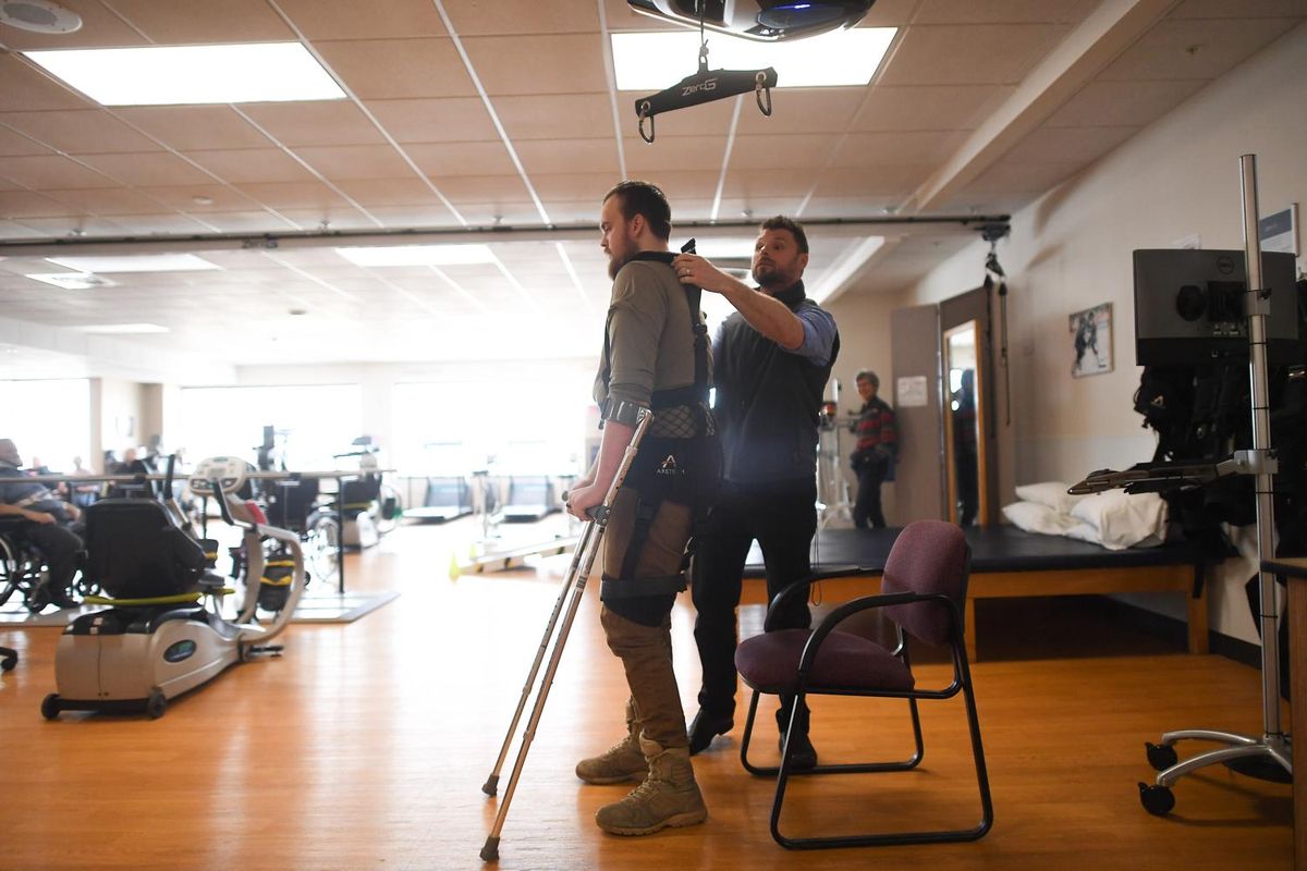 Jake Allstot, assistant manager of rehabilitation at St. Luke’s Rehabilitation Institute, helps Cameron Tweedy into a ZeroG Gait and Balance System during a demonstration of the machine and Tweedy’s recovery process on Jan. 30 at St. Luke’s Rehabilitation Institute in Spokane. (Tyler Tjomsland / The Spokesman-Review)