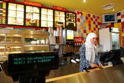 
An unidentified employee wearing an Islamic headscarf works at the counter of Beurger King Muslim, or BKM, at Clichy-sous-Bois, an eastern Paris suburb, on Thursday. 
 (Associated Press / The Spokesman-Review)