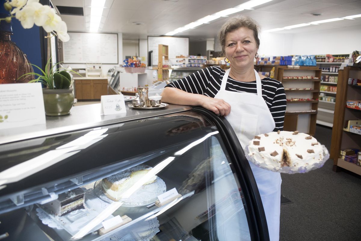 Esma Hatkic holds one of  Alpine Deli’s popular desserts, Kinder Bueno, a layered cream cake from Germany, Friday, June 30, 2017. Hatkic is part of a Bosnian family that took over the Alpine Deli that for many years was a place where Spokanites could find European cheeses, sausages, candies and desserts. The new owners have added some Bosnian foods. (Jesse Tinsley / The Spokesman-Review)