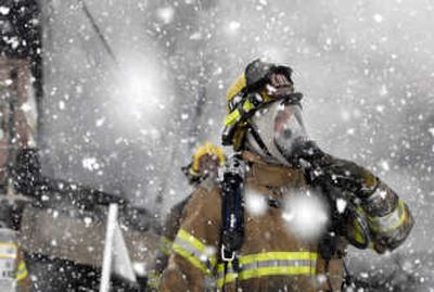 
Station 91 volunteer firefighter Robert Pilkinton stands near the scene of a  fire Saturday at 10311 E. Peone Landing Lane. 
 (Photos by J. BART RAYNIAK / The Spokesman-Review)