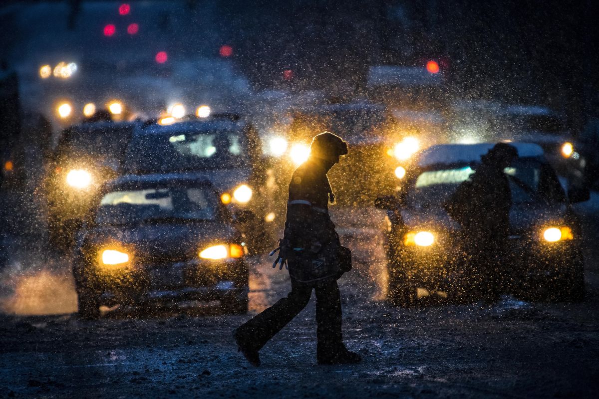 As the next wave of snow begins to fall, a pedestrian makes his way across Sprague Avenue at Lincoln Street in downtown Spokane, Wash., Monday, Feb. 11, 2019. (Colin Mulvany / The Spokesman-Review)