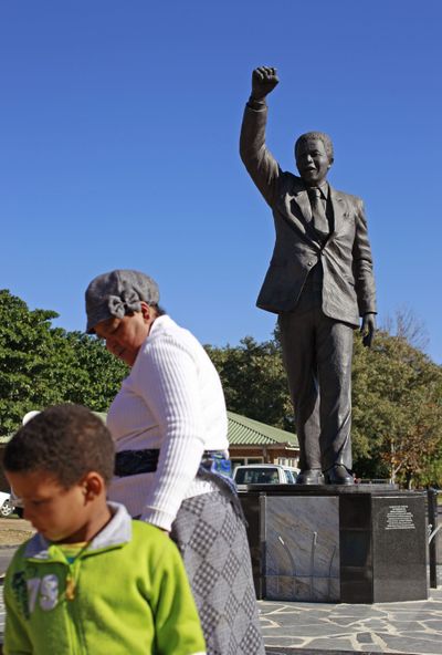 Visitors pay their respects at Nelson Mandela’s statue Sunday in South Africa. (Associated Press)
