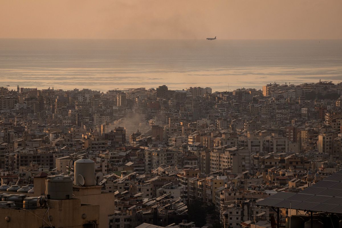 A plane comes into land as rubbish is burned in Beirut's southern suburbs, an Hezbollah stronghold and area which has been repeatedly targeted by Israeli airstrikes in the past month on Oct. 30, 2024, in Beirut, Lebanon.   (Ed Ram/Getty Images Europe/TNS)
