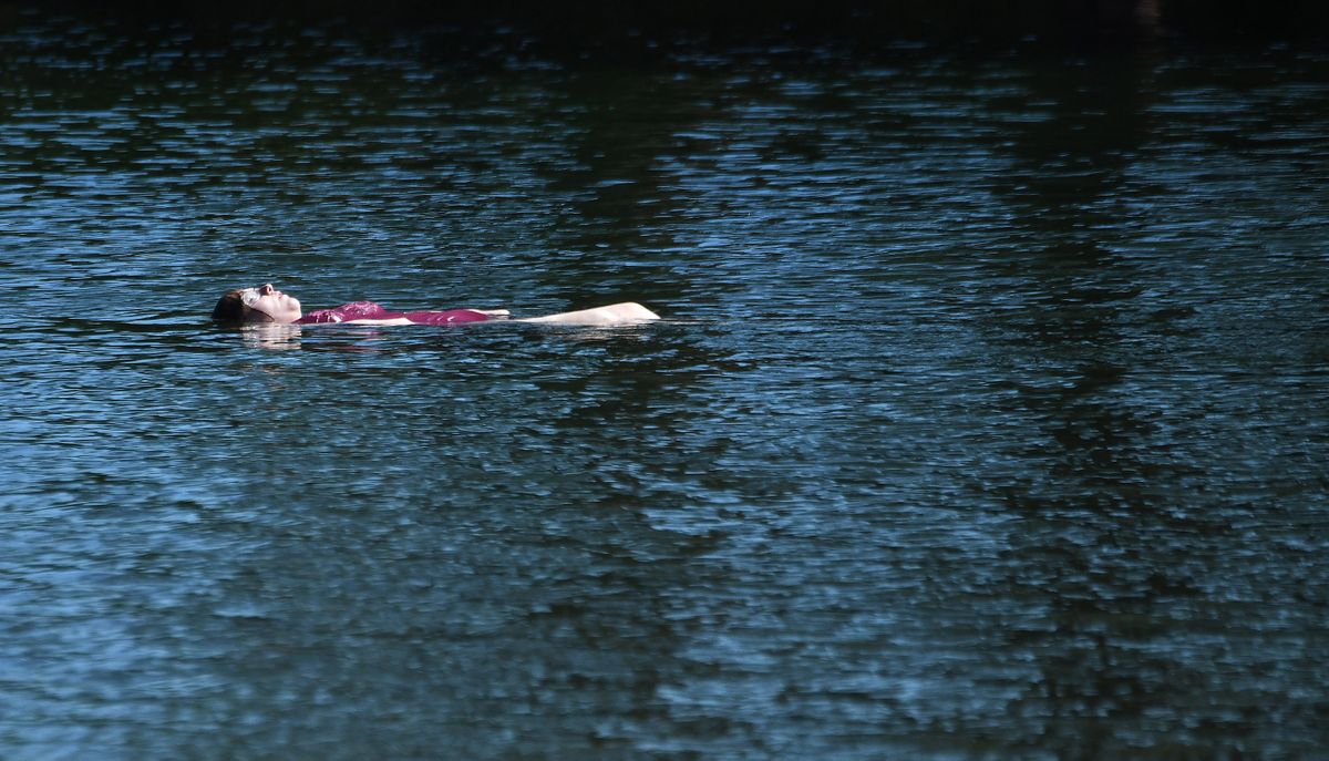 Amber Nelson of Spokane stays cool while floating in the Spokane River at Q
