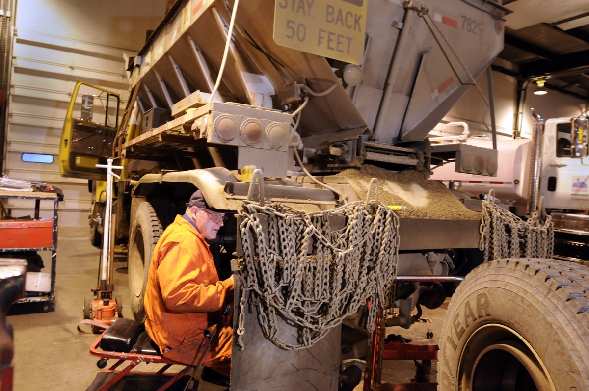 Mechanic Steve Fifield works on the brakes of a Spokane County sanding truck Thursday at the county shop in Spokane. County shop personnel have been busy converting dump trucks to snowplows and sanding trucks  in preparation for this weekend’s forecast of snowy, frigid weather.   (Jesse Tinsley / The Spokesman-Review)