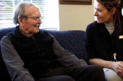 
Dom Kimpel, who has Alzheimer's disease, smiles as caregiver Monica Davis sits next to him at Park Place Retirement Community on Friday afternoon. 
 (Holly Pickett / The Spokesman-Review)