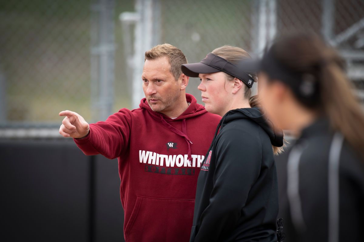 Whitworth Pirates' head softball coach Bob Castle, left, consults with Maddy Thomas, his top hitter who is also injured and can't start for the team in their conference playoffs, so she is doing a lot of coaching, while also preparing to be their designated player. Thomas, a senior, is also on the cusp of being Whitworth's all-time home run hitter.  (Jesse Tinsley/THE SPOKESMAN-REVI)