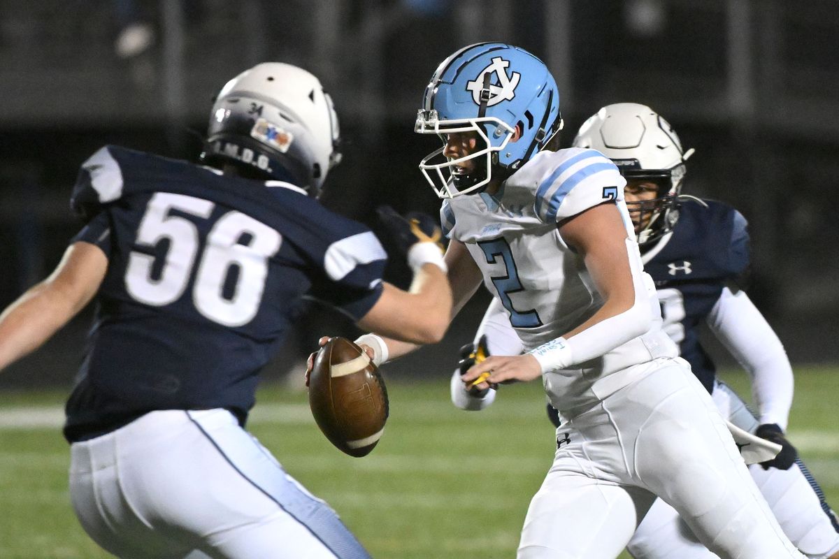Central Valley’s Bo Reisenauer is forced out of the pocket by Gonzaga Prep’s Nehemiah Areta, right, and Camden Fletcher during the first half Friday at Gonzaga Prep.  (James Snook)