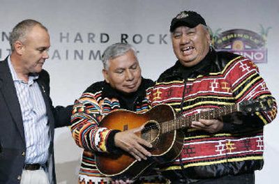 
Hard Rock Cafe International President and CEO Hamish Dodds, left, presents Seminole Indian tribal leaders Andrew Bowers Jr. and Max Osceola with a Hank Willilams Sr. guitar during a news conference at the Hard Rock Cafe in New York, after the tribe announced it had acquired Hard Rock International. The tribe purchased Hard Rock International in a $965 million deal.
 (Associated Press / The Spokesman-Review)