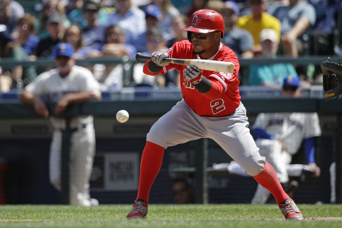 Angels’ Erick Aybar lays down a sacrifice bunt that resulted in Mike Trout scoring after pitcher Taijuan Walker’s throwing error. (Associated Press)