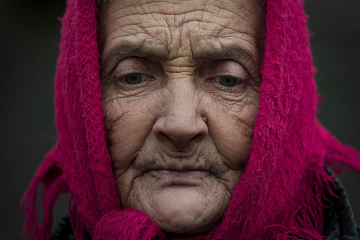 Valentyna Melnychenko looks down as members of the Joint Centre for Control and Coordination on ceasefire of the demarcation line survey damage to her home from an artillery shell landed Thursday in Vrubivka, one of the at least eight that hit the village today, according to officials in the Luhansk region of eastern Ukraine. (Vadim Ghirda)
