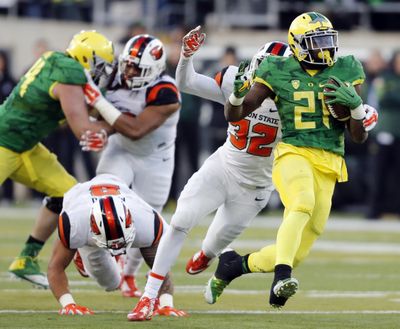 Oregon RB Royce Freeman, right, tries to pull away in Ducks’ 52-42 win.