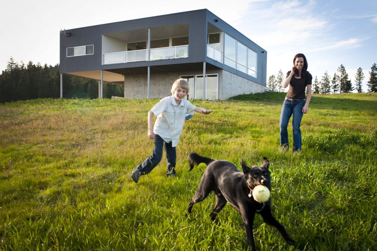 Kathryn Jones and her son Jackson, 9, exercise their dog in the front yard of their new home built on a hillside near Freeman, Wash. The house is designed in a minimalist architectural style and was used in the filming of the “The Big Bang†staring Antonio Banderas, which came out on DVD May 24. (Colin Mulvany)