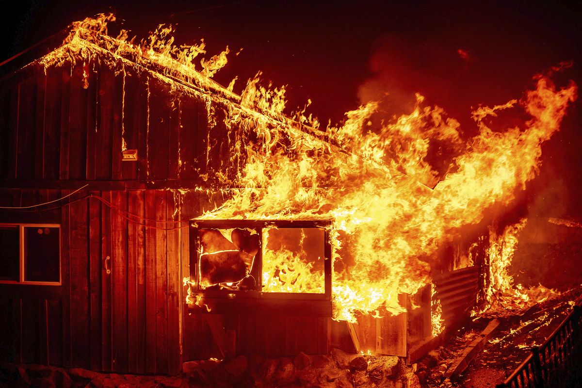 Flames shoot from a home as the Bear Fire burns through the Berry Creek area of Butte County, Calif., on Wednesday, Sept. 9, 2020. The blaze, part of the lightning-sparked North Complex, expanded at a critical rate of spread as winds buffeted the region.  (Noah Berger)