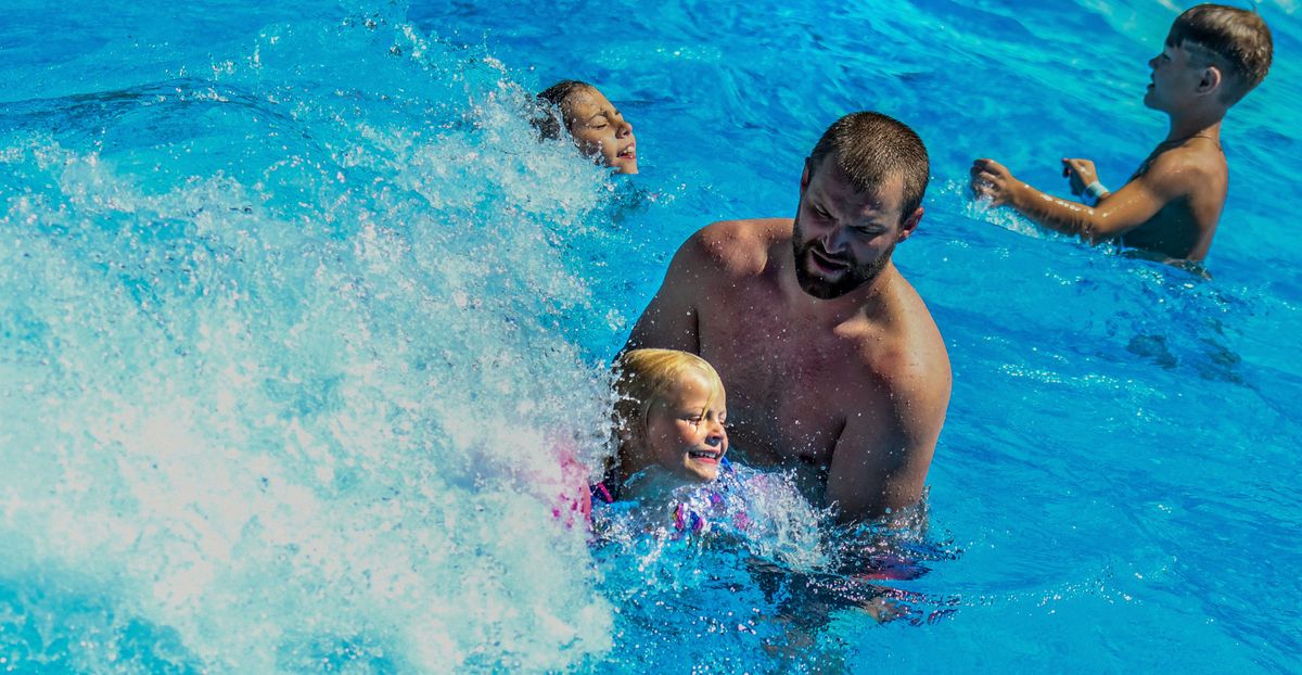 Molly Lomsdalen, 5, plays in the wave pool at Boulder Beach Water Park at Silverwood along with her dad, Michael, on July 28.  (Kathy Plonka/The Spokesman-Review)