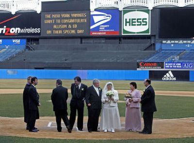 
Flanked by their wedding party, newlyweds Allison and Ed Lucas, third and fourth from right, pause a moment Friday after taking their vows on the field of Yankee Stadium – a first for the ballpark. 
 (Associated Press / The Spokesman-Review)