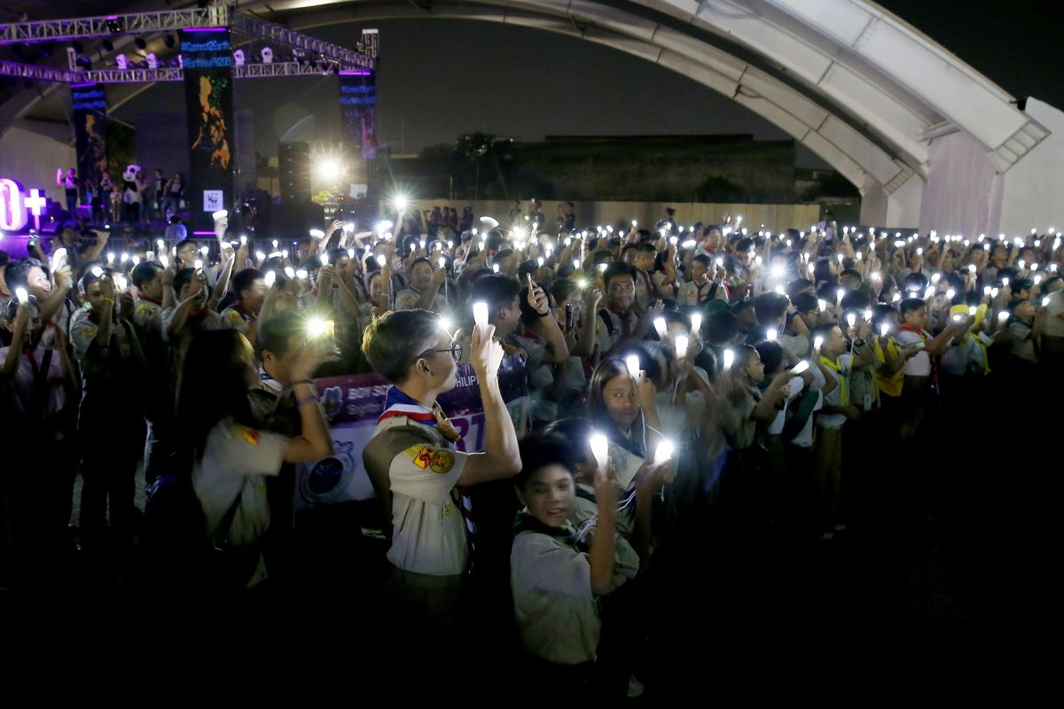 Philippine Boy Scouts switch on their flashlights at the countdown for the 12th Earth Hour event Saturday, March 30, 2019 in  Makati city east of Manila, Philippines. (Bullit Marquez / AP)