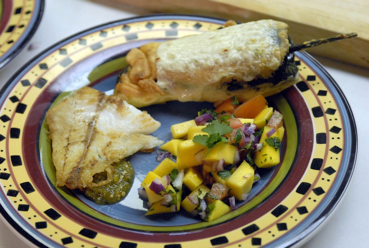 One of Myers’ meals consists of chili rellenos, top, pan-fried fish and mango salsa. (Jesse Tinsley / The Spokesman-Review)