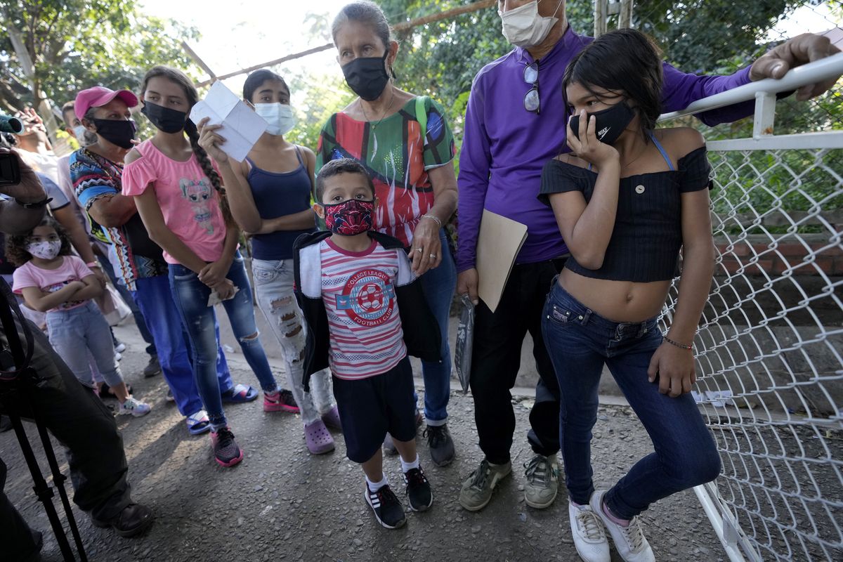 Venezuelans citizen wait in line to receive a dose of a COVID-19 vaccine in La Parada, near Cucuta, Colombia, Friday, Nov. 12, 2021. Over the past two weeks Colombia has provided COVID-19 vaccines to thousands of Venezuelans.  (Fernando Vergara)