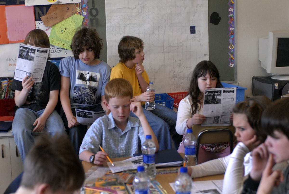 The Spokesman-Review Seth Woodard teacher Haley Murray teaches 29 PACE students with the help of a full-time aide and parent volunteers, as her group is the largest class in the school. “It’s organized chaos,” she said. “But the kids so thrive in that environment.” Members of “Noname” and “Flying Monkeys” read passages from a book that presents history in a creative news format. Her social studies curriculum incorporates math, social studies, writing and reading. (J. BART RAYNIAK / The Spokesman-Review)