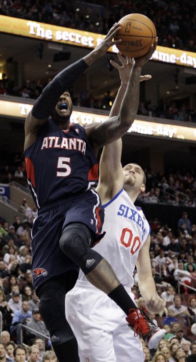 Hawks’ Josh Smith goes up for a shot against 76ers’ Spencer Hawes. (Associated Press)