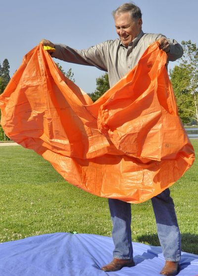 Gov. Jay Inslee practices deploying a fire shelter Wednesday. (Jim Camden)