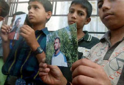 
Palestinian children hold undated photos of Hamas leader Izz Eldine Subhi Sheik Khalil, who was killed Sunday in a car bomb attack in Damascus, Syria. 
 (Associated Press / The Spokesman-Review)