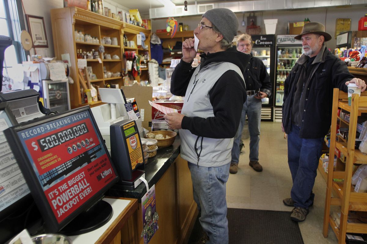 Retired Dr. Paul Kruzel kisses his lottery ticket for luck after buying it at the Canterbury Country Store Wednesday, Nov. 28, 2012 in Canterbury, N.H. (Jim Cole / Associated Press)