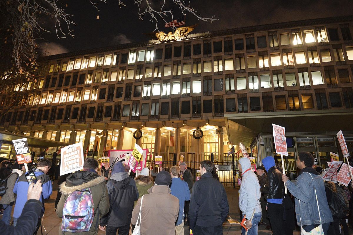 People gather to protest outside the US Embassy in London Friday Dec. 1, 2017. (John Stillwell / AP)