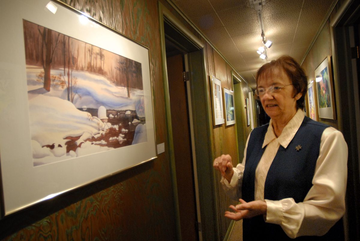 Betty Bradley stands by one of her watercolor paintings in the hallway of her North Spokane home. Bradley is a Franciscan Sister of Perpetual Adoration and has been painting since 1990. (Kate Clark / The Spokesman-Review)