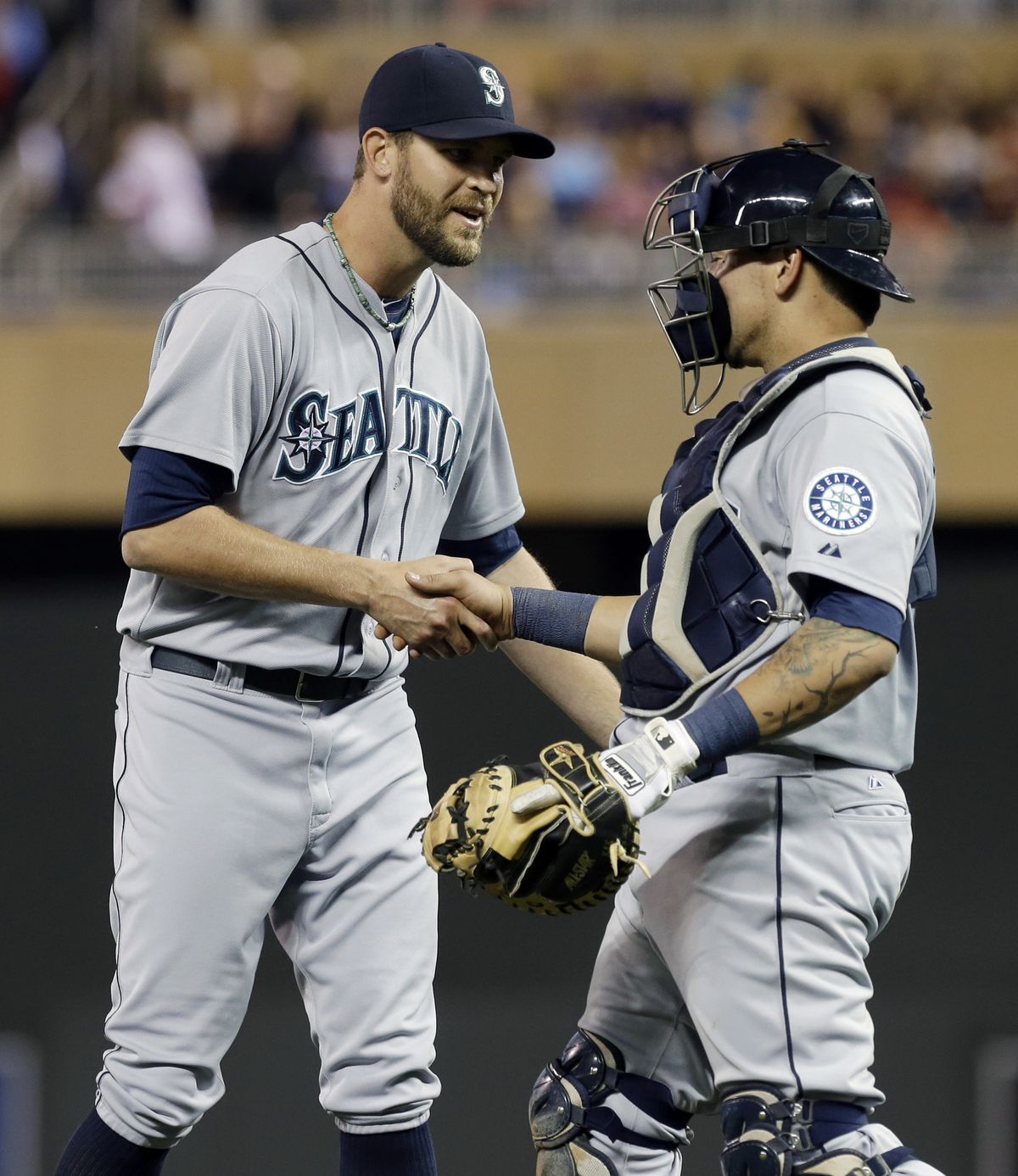Mariners closer Tom Wilhelmsen, left, and catcher Jesus Sucre shake hands after the team’s 3-0 shutout of the Twins. (Associated Press)