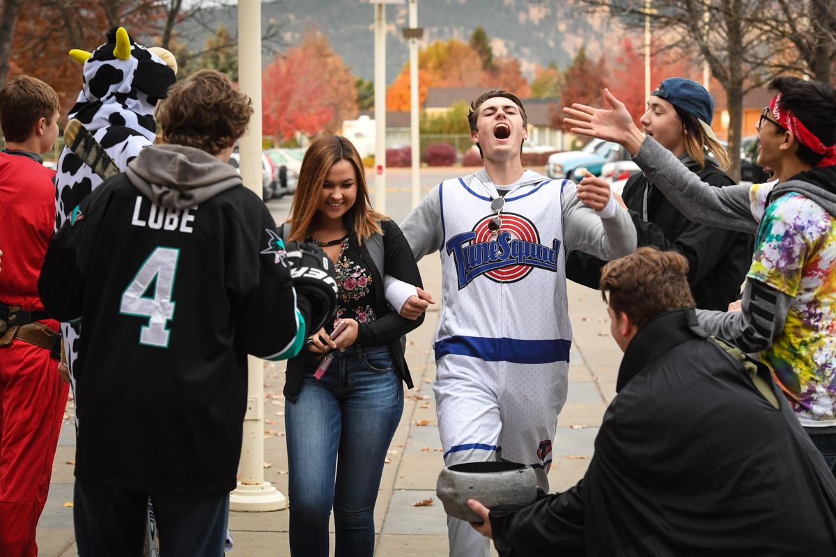 University High School senior Clay Murock, in costume, escorts his girlfriend, Natalee Nerren, also a senior past a group of students welcoming fellow Titans to school Thursday morning, Oct. 25, 2018, in Spokane Valley, Wash. (Dan Pelle / The Spokesman-Review)