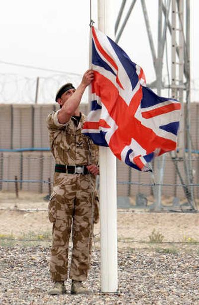 
A British army corporal lowers the Union Jack during an April ceremony to mark transfer of control of a British military base in Basra. British soldiers began withdrawing Sunday from their last base in Basra.Associated Press
 (Associated Press / The Spokesman-Review)