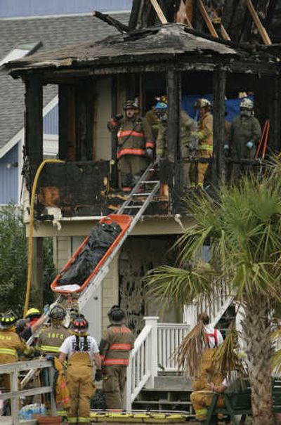 
Firefighters lower a body out of a beach house that burned Sunday at Ocean Isle Beach, N.C. Associated Press
 (Associated Press / The Spokesman-Review)