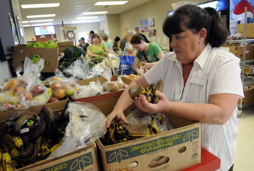 Theresa Ray sorts through bananas for Spokane Valley Partners Food Bank. She works at NOVA services and volunteers at the food bank. She also brings NOVA clients with her for job training.  (J. Bart Rayniak)