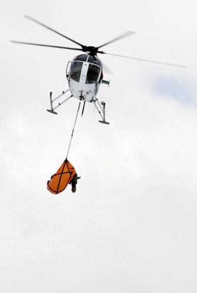 A blindfolded moose is flown by helicopter to a handling site after being captured in the wild Friday in Utah. As many as 25 animals are being transported to Colorado.
(Associated Press / The Spokesman-Review)