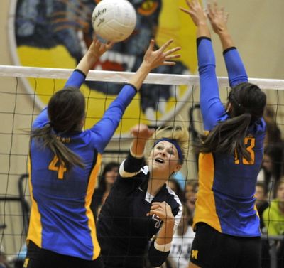 Mt. Spokane's Annie Arnzen (4) tries to smash a shot between Mead's Kaely Kight (4) and Hanna Zalopany (13). (Dan Pelle / The Spokesman-Review)