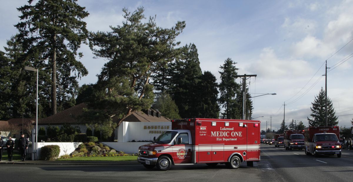 The bodies of four slain Lakewood Police officers arrive in a procession at the Mountain View Funeral Home, Tuesday, Dec. 1, 2009, in Lakewood, Wash.  (Ted Warren / Associated Press)