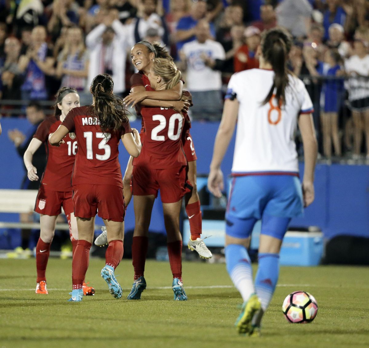 U.S. midfielder Allie Long (20) hugs Mallory Pugh as they celebrate a goal by Long with Rose Lavelle (16) and Alex Morgan (13) in the second half of an international friendly soccer match against Russia in Frisco, Texas, Thursday, April 6, 2017. Russia defender Daria Makarenko (8) walks by. (Tony Gutierrez / Associated Press)