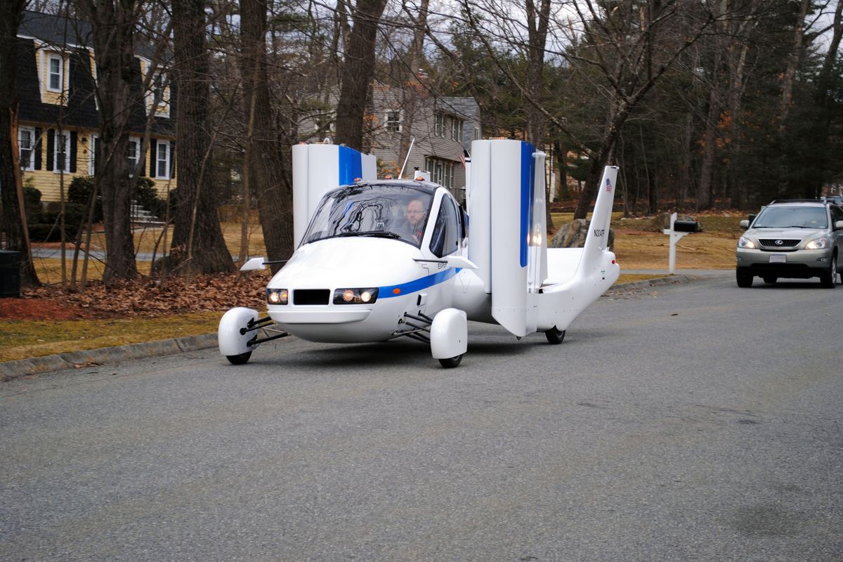 Terrafugia Inc.’s prototype flying car, dubbed the Transition, travels down a street with its wings folded. The vehicle has two seats and four wheels. (Associated Press)
