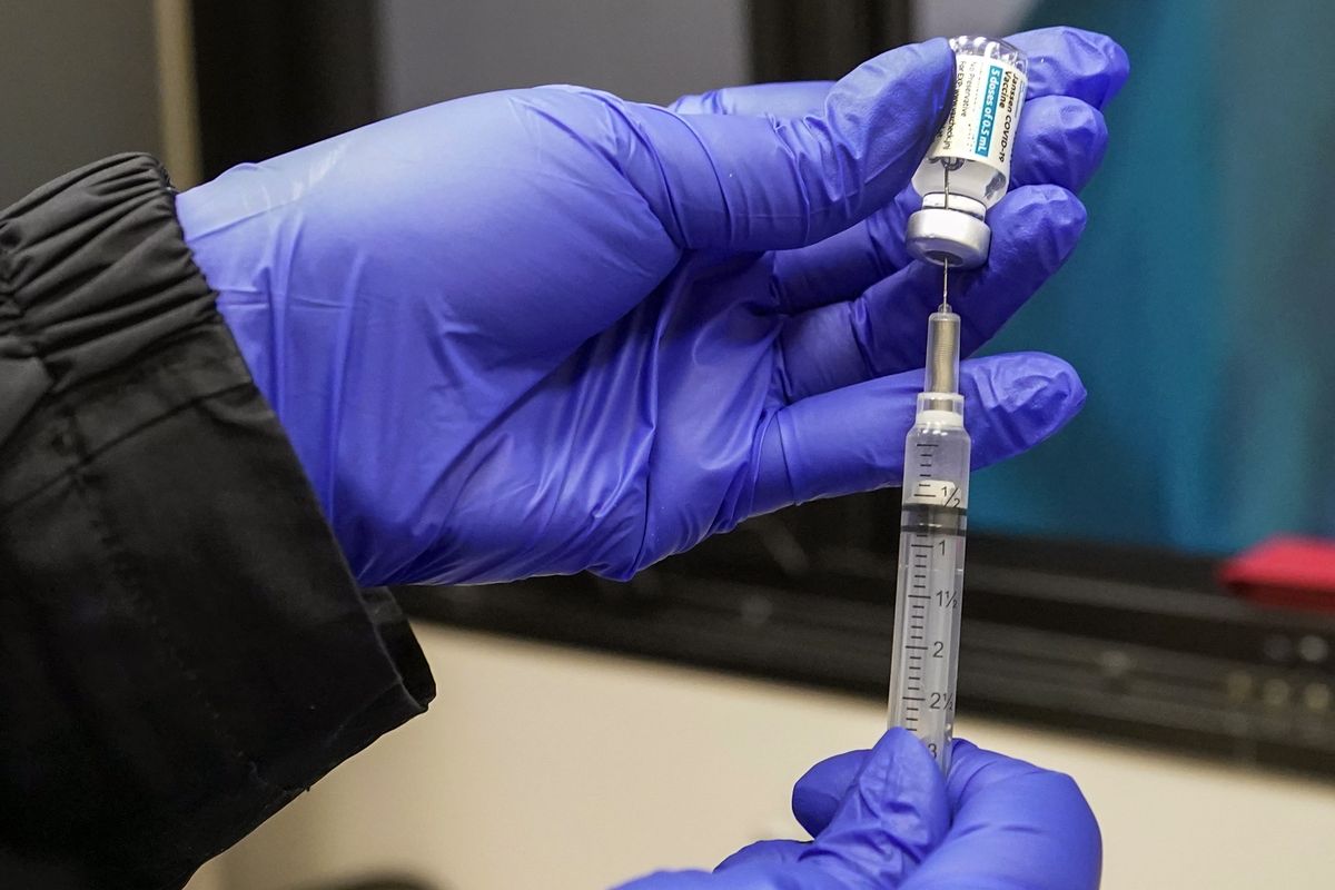 FILE — In this March 31, 2021 file photo, a nurse fills a syringe with a dose of the Johnson & Johnson