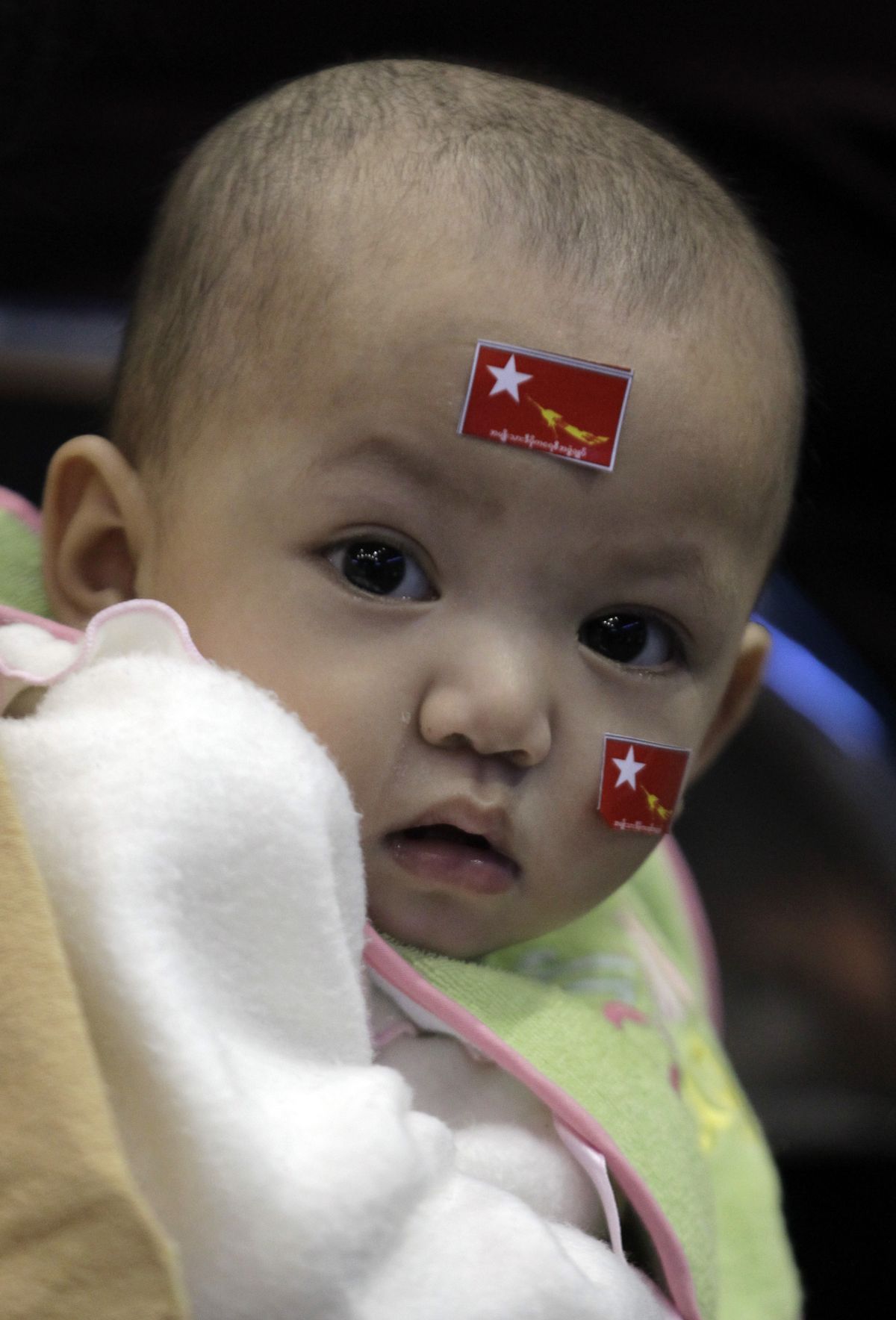 A infant in the audience wears the flag of Myanmar pro-democracy leader Aung San Suu Kyi