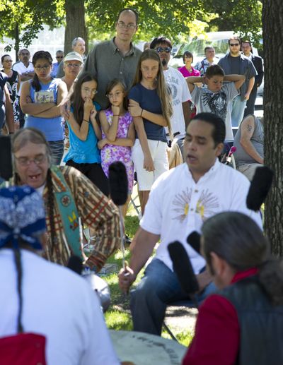 Brian Huseland and his daughters, Mercy, 10, Irene, 8, and Alice, 13, listen to a drum circle from Wellpinit, Wash., in Garry Park Wednesday. (Colin Mulvany)