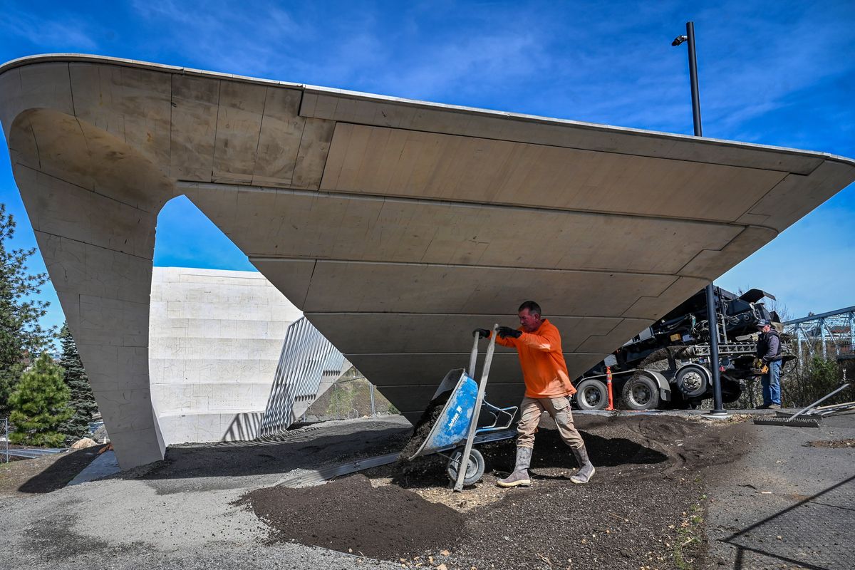 Rob Bacon, of Bacon Concrete, drops a load of top soil on the north end of the Stepwell artwork, Tuesday, April 25, 2023 in downtown Spokane. Stepwell is the final piece of art to be completed as part of the Riverfront Park redevelopment that began a decade ago.  (DAN PELLE/THE SPOKESMAN-REVIEW)