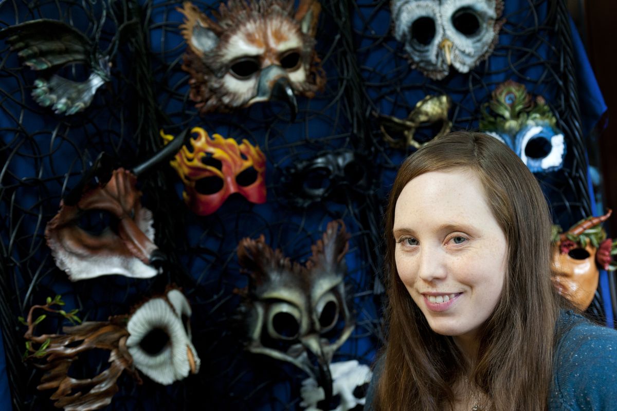 Libertini poses for a photo with some of her leather masks at her home on July 3 in Spokane. They are formed into birds, animals and curious humans. The masks are functional – meant to be worn – as well as decorative, to be hung on the wall. Libertini is also a painter.