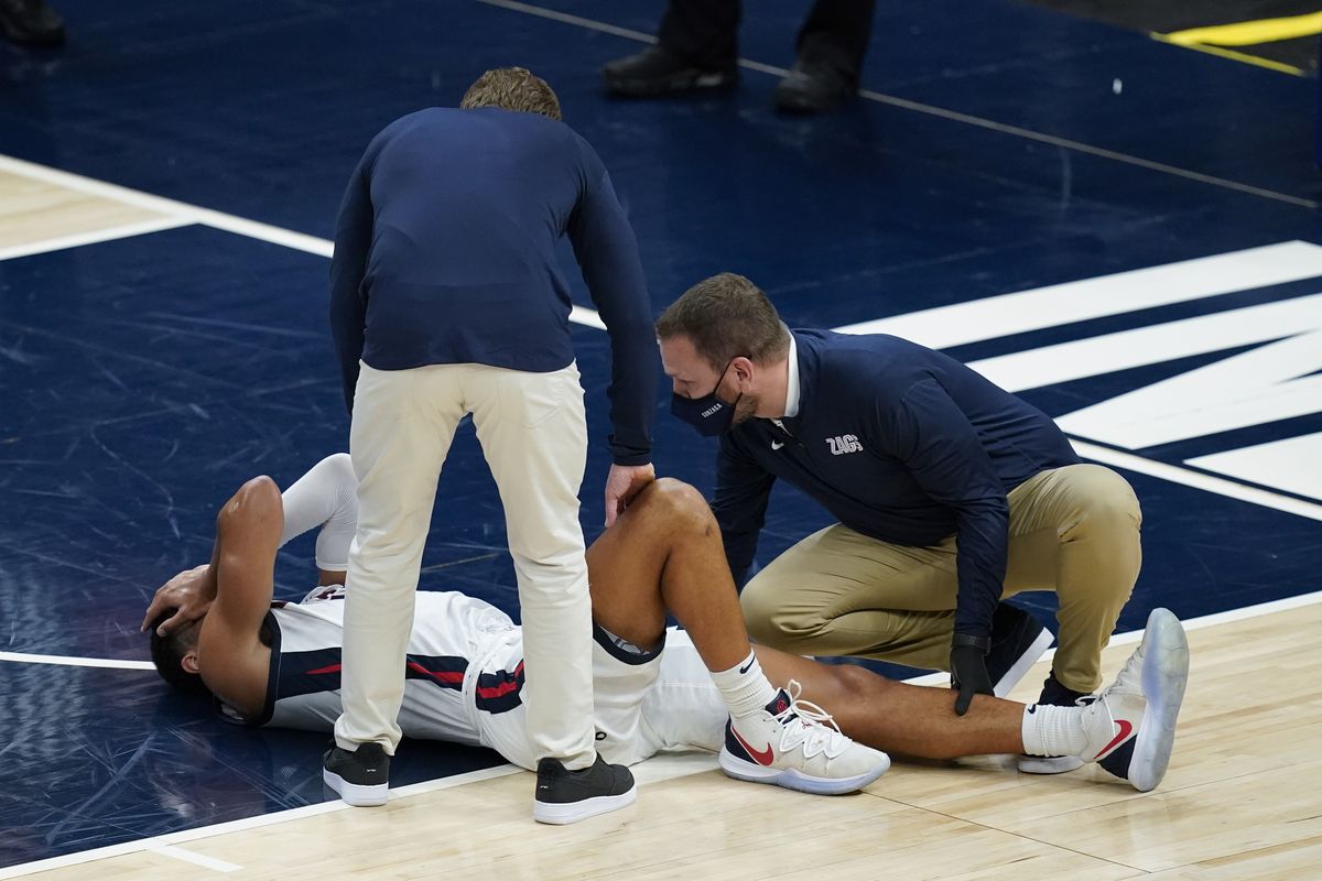 Gonzaga coach Mark Few stands over Jalen Suggs (1) as the player is examined during the first half of the Bulldogs’ game against West Virginia on Wednesday in Indianapolis.  (Associated Press)