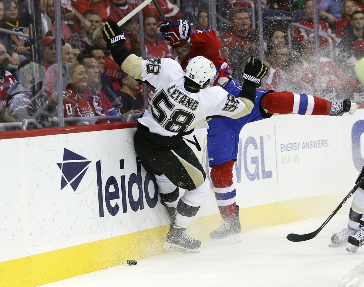 In this April 7, 2016, file photo, Pittsburgh Penguins defenseman Kris Letang (58) and Washington Capitals right wing T.J. Oshie (77) collide against the boards in the first period of an NHL hockey game, in Washington. Like tourists flocking to see the cherry blossoms in full bloom, the Pittsburgh Penguins making a trip to Washington for the playoffs has become a rite of spring. (Alex Brandon / Associated Press)